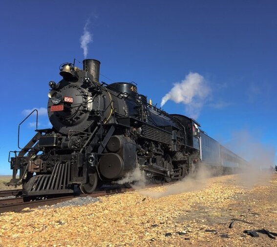Steam Locomotive pulling passenger train. Red and Brass 