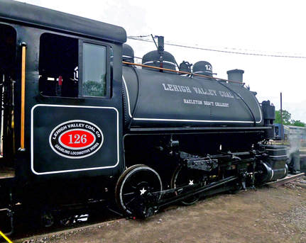Side of Black Steam Tank Engine. 126 is written in red and white below the engineers window. 